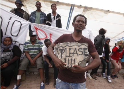  VENTIMIGLIA, ITALY - JUNE 16:Migrants stay on rocks as they wait to cross into France,in the French-Italian border,on June 16, 2015 in Ventimiglia, Italy.Some 200 migrants from Africa are being blocked by French authorities to enter the country from Ventimiglia in Italy since June 11.(Photo by Patrick Aventurier)