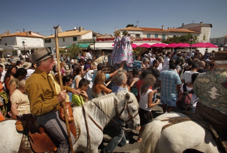  SAINTES MARIES DE LA MER, FRANCE -MAY 25:The crowd of gypsies and non-gypsies pilgrims ,Gardians on horseback and Arlesienne girls in costume accompanied to the sea the ‟craft‟,with the statues of the Two Marys aboard.Roms,Manouches,Tziganes and other gypsies  come from all over Europe and even from other continents to worship their Saint , Sara the black.The statues carried by the Gypsies to the sea, symbolizes the waiting forand welcome of the Saints Mary Jacobe and Mary SalomeThis march to the sea is in memory of the arrival of their saint.on July 10, 2010 in Saintes Maries de la mer, France. (Photo by Patrick Aventurier/Getty Images) 