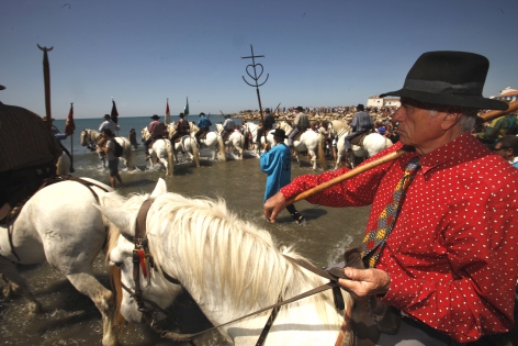  SAINTES MARIES DE LA MER, FRANCE -MAY 25:The crowd of gypsies and non-gypsies pilgrims ,Gardians on horseback and Arlesienne girls in costume accompanied to the sea the ‟craft‟,with the statues of the Two Marys aboard.Roms,Manouches,Tziganes and other gypsies  come from all over Europe and even from other continents to worship their Saint , Sara the black.The statues carried by the Gypsies to the sea, symbolizes the waiting forand welcome of the Saints Mary Jacobe and Mary SalomeThis march to the sea is in memory of the arrival of their saint.on July 10, 2010 in Saintes Maries de la mer, France. (Photo by Patrick Aventurier/Getty Images) 