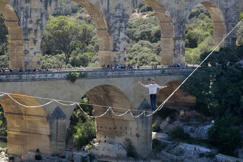  VERS-PONT-DU-GARD, FRANCE - JULY 09:French tightrope walker Nathan Paulin walk on a slackline at the Pont du Gard, a Roman aqueduct bridge part of the UNESCO's list of World Heritage Site, in Vers-Pont-du-Gard southern France, during the Crater Surfaces festival,on July 9, 2022 in Vers-Pont-du-Gard, France. (Photo by Patrick Aventurier/Getty Images)