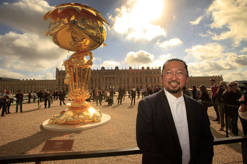  VERSAILLES-FRANCE-9september2010 : The japaneseTakashi Murakami exhibition at the chateau de Versailles.The first major retrospective in France , in 15 rooms of the chateau and in the garden,Murakami present 22 major works, of which 11 have been created exclusively for this exhibition(Photo by Patrick Aventurier/Getty Images) Murakami in front the oval Buddha
